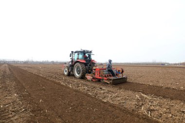 LUANNAN COUNTY, Çin - 16 Mart 2022: Çiftçiler tarlalarına yulaf ekmek için ekicileri kullanır, Kuzey Çene