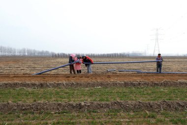 LUANNAN, Çin - 18 Mart 2022: İşçiler su tasarrufu boru hatları döşüyorlar ve yüksek standartlı tarım arazisi inşaat projeleri uyguluyorlar, Kuzey Çin