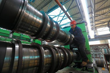 LUANNAN COUNTY, Çin - 11 Ağustos 2021: İşçiler Kuzey Çin 'deki fabrikadaki şerit çelik üretim hattı üzerinde sıkı çalışıyorlar