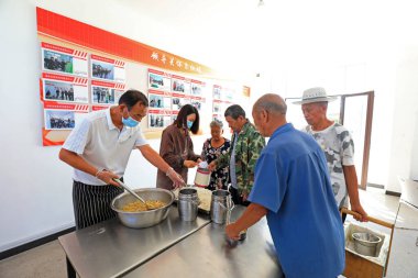 LUANNAN COUNTY, Çin - 7 Eylül 2021: aşçı Kuzey Çin kırsal kantininde yemek servisi yapıyor