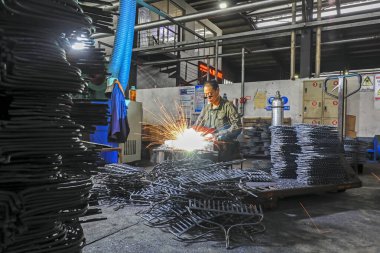 LUANNAN COUNTY, Çin - 24 Eylül 2021: işçiler yoğun bir şekilde Kuzey Çin 'deki bir donanım üretim fabrikasında üretim bandı üzerinde çalışıyorlar.