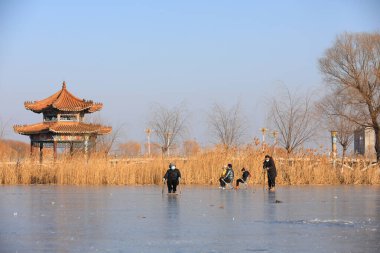 LUANNAN COUNTY, Çin - 15 Ocak 2022: İnsanların buz pateni fotoğraflarını çeken fotoğrafçı