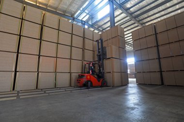 LUANNAN COUNTY, Çin - 26 Şubat 2022: İşçiler forkliftleri Kuzey Çin 'deki fabrikada yoğunluk tahtası ürünlerini taşımak için kullanıyorlar
