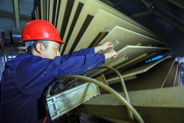 LUANNAN COUNTY, Çin - 26 Şubat 2022: İşçiler Kuzey Çin 'deki fabrikadaki parçacık üretim hattı üzerinde sıkı çalışıyorlar