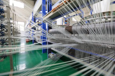Plastik örgü üretim hattının mekanik ekipmanları bir fabrikada çalışıyor.