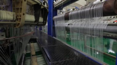 Yüksek hızlı dönen plastik dokuma makineleri Kuzey Çin 'de bir üretim atölyesinde.