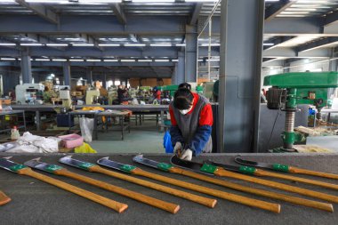 LUANNAN COUNTY, Çin - 5 Nisan 2022: işçiler Kuzey Çin 'deki bir nalbur imalat şirketinde çelik kürek üretim hattı üzerinde sıkı çalışıyorlar.