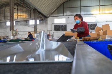 LUANNAN COUNTY, Çin - 5 Nisan 2022: işçiler Kuzey Çin 'deki bir nalbur imalat şirketinde çelik kürek üretim hattı üzerinde sıkı çalışıyorlar.