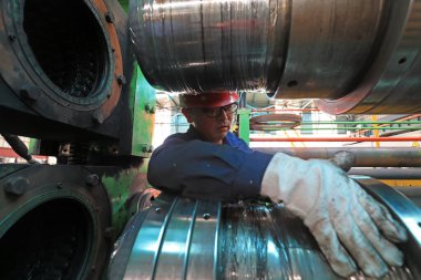 LUANNAN COUNTY, Çin - 11 Ağustos 2021: İşçiler Kuzey Çin 'deki fabrikadaki şerit çelik üretim hattı üzerinde sıkı çalışıyorlar