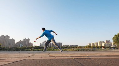 LUANNAN COUNTY, Çin - 14 Eylül 2021: Bir adam parkta diabolo fitness sallıyor, North Chin