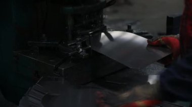 İşçiler, Kuzey Çin 'deki bir kürek fabrikasının çelik kürek üretim hattında çok sıkı çalışıyorlar.