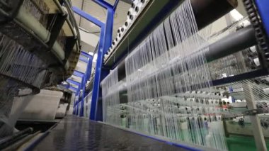 Yüksek hızlı dönen plastik dokuma makineleri Kuzey Çin 'de bir üretim atölyesinde.