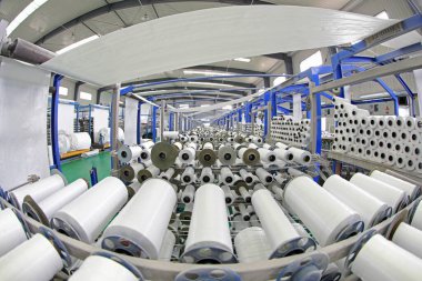 Plastik örgü üretim hattının mekanik ekipmanları bir fabrikada çalışıyor.