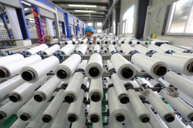 İşçiler Kuzey Çin 'deki plastik dokuma atölyesinde sıkı çalışıyorlar.