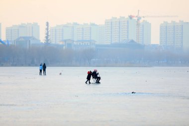 LUANNAN COUNTY, Çin - 8 Ocak 2022: turistler Kuzey Çin 'deki donmuş nehirde kayıyorlar