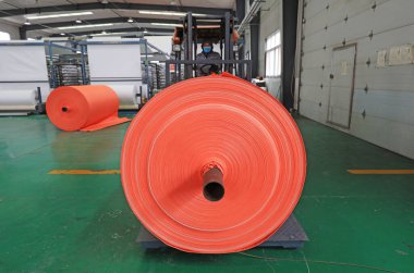 LUANNAN COUNTY, China - January 12, 2022: Workers drive forklifts to transport plastic fiber materials, North Chin clipart