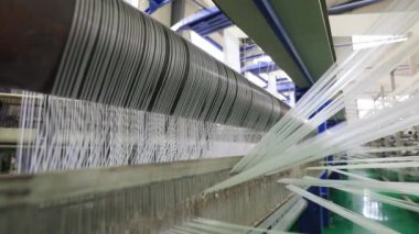 Yüksek hızlı dönen plastik dokuma makineleri Kuzey Çin 'de bir üretim atölyesinde.