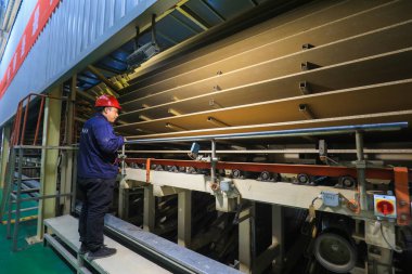 LUANNAN COUNTY, Çin - 26 Şubat 2022: İşçiler Kuzey Çin 'deki fabrikadaki parçacık üretim hattı üzerinde sıkı çalışıyorlar