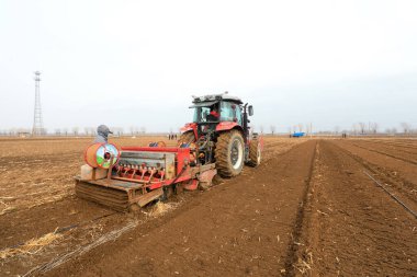 LUANNAN COUNTY, Çin - 16 Mart 2022: Çiftçiler tarlalarına yulaf ekmek için ekicileri kullanır, Kuzey Çene