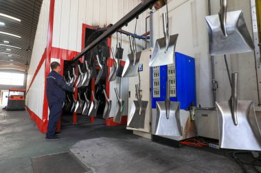 LUANNAN COUNTY, Çin - 5 Nisan 2022: işçiler Kuzey Çin 'deki bir nalbur imalat şirketinde çelik kürek üretim hattı üzerinde sıkı çalışıyorlar.