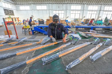 LUANNAN COUNTY, Çin - 5 Nisan 2022: işçiler Kuzey Çin 'deki bir nalbur imalat şirketinde çelik kürek üretim hattı üzerinde sıkı çalışıyorlar.