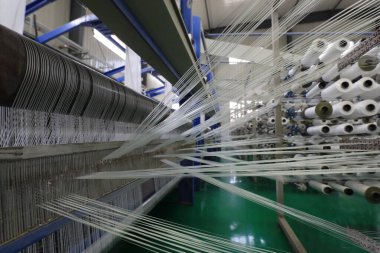 Plastik örgü üretim hattının mekanik ekipmanları bir fabrikada çalışıyor.