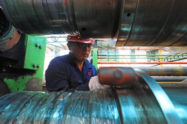 LUANNAN COUNTY, Çin - 11 Ağustos 2021: İşçiler Kuzey Çin 'deki fabrikadaki şerit çelik üretim hattı üzerinde sıkı çalışıyorlar