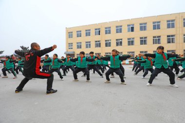 LUANNAN COUNTY, Çin - 9 Aralık 2021: İlkokul öğrencileri Çin 'in geleneksel dövüş sanatları becerilerinin temel becerilerini Kuzey Çin' de uyguluyorlar.