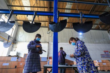 LUANNAN COUNTY, Çin - 5 Nisan 2022: işçiler Kuzey Çin 'deki bir nalbur imalat şirketinde çelik kürek üretim hattı üzerinde sıkı çalışıyorlar.