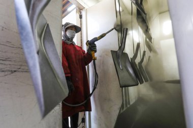 LUANNAN COUNTY, Çin - 5 Nisan 2022: işçiler Kuzey Çin 'deki bir nalbur imalat şirketinde çelik kürek üretim hattı üzerinde sıkı çalışıyorlar.