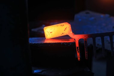 Yüksek sıcaklıkta dövülen çelik bölme bir donanım alet fabrikasında.