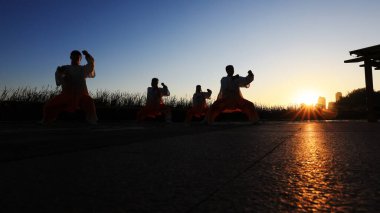 İnsanlar Kuzey Çin 'deki parkın ahşap platformunda Taijiquan pratiği yapıyorlar.