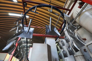 İşçiler, Kuzey Çin 'deki bir nalbur imalat şirketinde çelik kürek üretim hattı üzerinde sıkı çalışıyorlar.