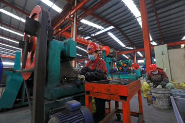 LUANNAN COUNTY, China - April 22, 2021: female workers work hard on the production line in a shovel factory in North China clipart