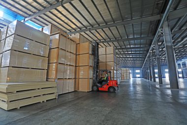 LUANNAN COUNTY, Çin - 9 Ağustos 2021: İşçiler Çin 'deki fabrikada ahşap tahta ürünleri taşımak için forklift kullanıyorlar