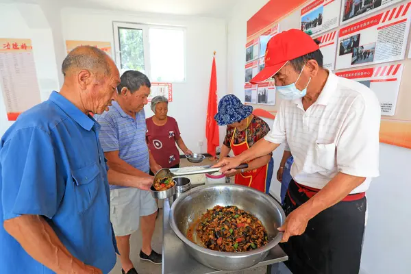 LUANNAN COUNTY, Çin - 8 Temmuz 2021: Çin kırsalında pirinç ve sebze servisi yapan kantin personeli