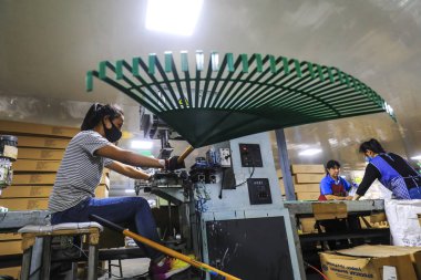 LUANNAN COUNTY, Çin - 24 Eylül 2021: işçiler Kuzey Çin 'deki bir donanım üretim şirketinde çelik kürek ve tırmık üretim hattı üzerinde sıkı çalışıyorlar