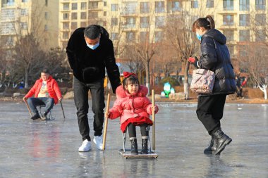 LUANNAN COUNTY, Çin - 8 Ocak 2022: turistler Kuzey Çin 'deki donmuş nehirde kayıyorlar