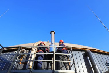 LUANNAN COUNTY, Çin - 10 Ocak 2022: İşçiler Kuzey Çin 'deki anaerobik fermantasyon tankının dışında devriye teftişi yapıyorlar