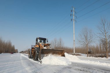 LUANNAN COUNTY, Çin - 14 Şubat 2022: Otoyol trafik yöneticileri otoyoldaki karı temizlemek ve Kuzey Çin 'de otoyolun açılmasını sağlamak için forkliftler kullanıyor.