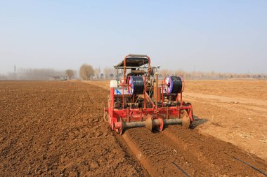 LUANNAN COUNTY, Çin - 9 Mart 2022: Çiftçiler tarlaları düzenlemek ve Kuzey Çin 'deki tarlada Çin lahanası ekmeye hazırlanmak için tarım makineleri sürüyorlar