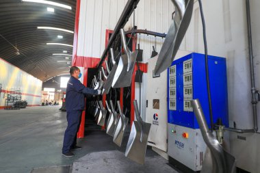 LUANNAN COUNTY, Çin - 5 Nisan 2022: işçiler Kuzey Çin 'deki bir nalbur imalat şirketinde çelik kürek üretim hattı üzerinde sıkı çalışıyorlar.