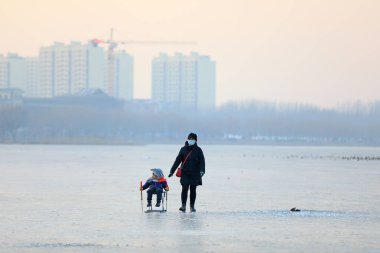 LUANNAN COUNTY, Çin - 8 Ocak 2022: turistler Kuzey Çin 'deki donmuş nehirde kayıyorlar