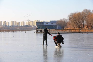 LUANNAN COUNTY, Çin - 15 Ocak 2022: Ziyaretçiler Kuzey Çin 'deki parkta paten kayıyorlar
