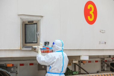 LUANNAN COUNTY, Çin - 29 Mart 2022: Tıp çalışanları nükleik asit test örneklerini Kuzey Çin 'deki mobil tıp laboratuarına transfer ettiler.