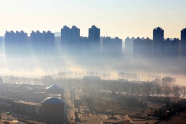 Buildings in advection fog, beautiful urban scenery, North China clipart