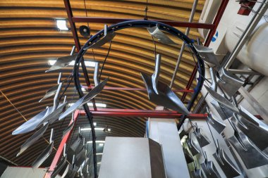 İşçiler, Kuzey Çin 'deki bir nalbur imalat şirketinde çelik kürek üretim hattı üzerinde sıkı çalışıyorlar.