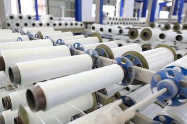 Plastik örgü üretim hattının mekanik ekipmanları bir fabrikada çalışıyor.