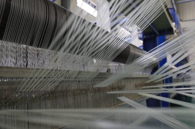 Plastik örgü üretim hattının mekanik ekipmanları bir fabrikada çalışıyor.
