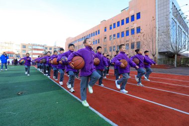 LUANNAN COUNTY, Çin - 2 Aralık 2021: İlkokul öğrencileri Kuzey Çin 'deki kampüste senkronize basketbol oynuyorlar